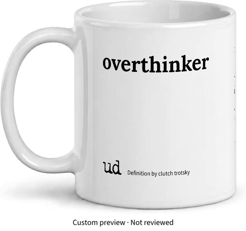 Front of a white mug with overthinker in large black lettering and Definition by clutch trotsky beside the UD logo